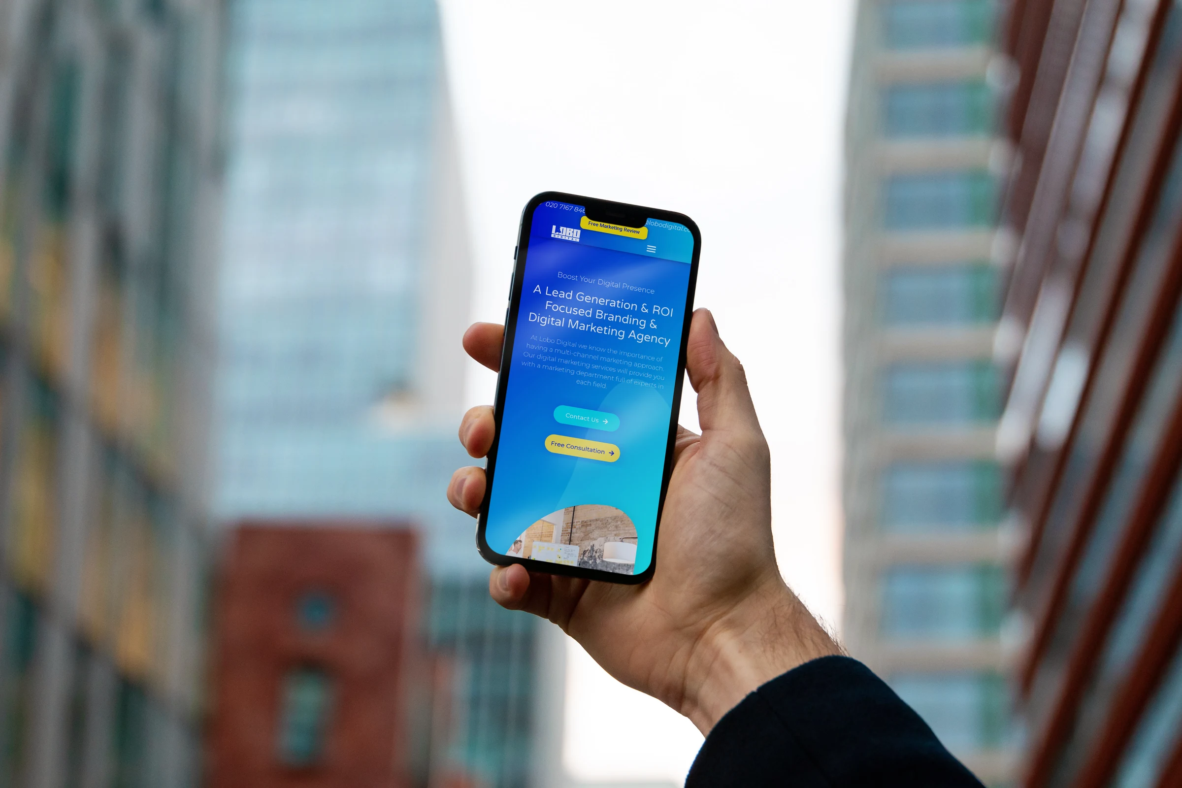 Man holding a phone which displays the Lobo Digital Website