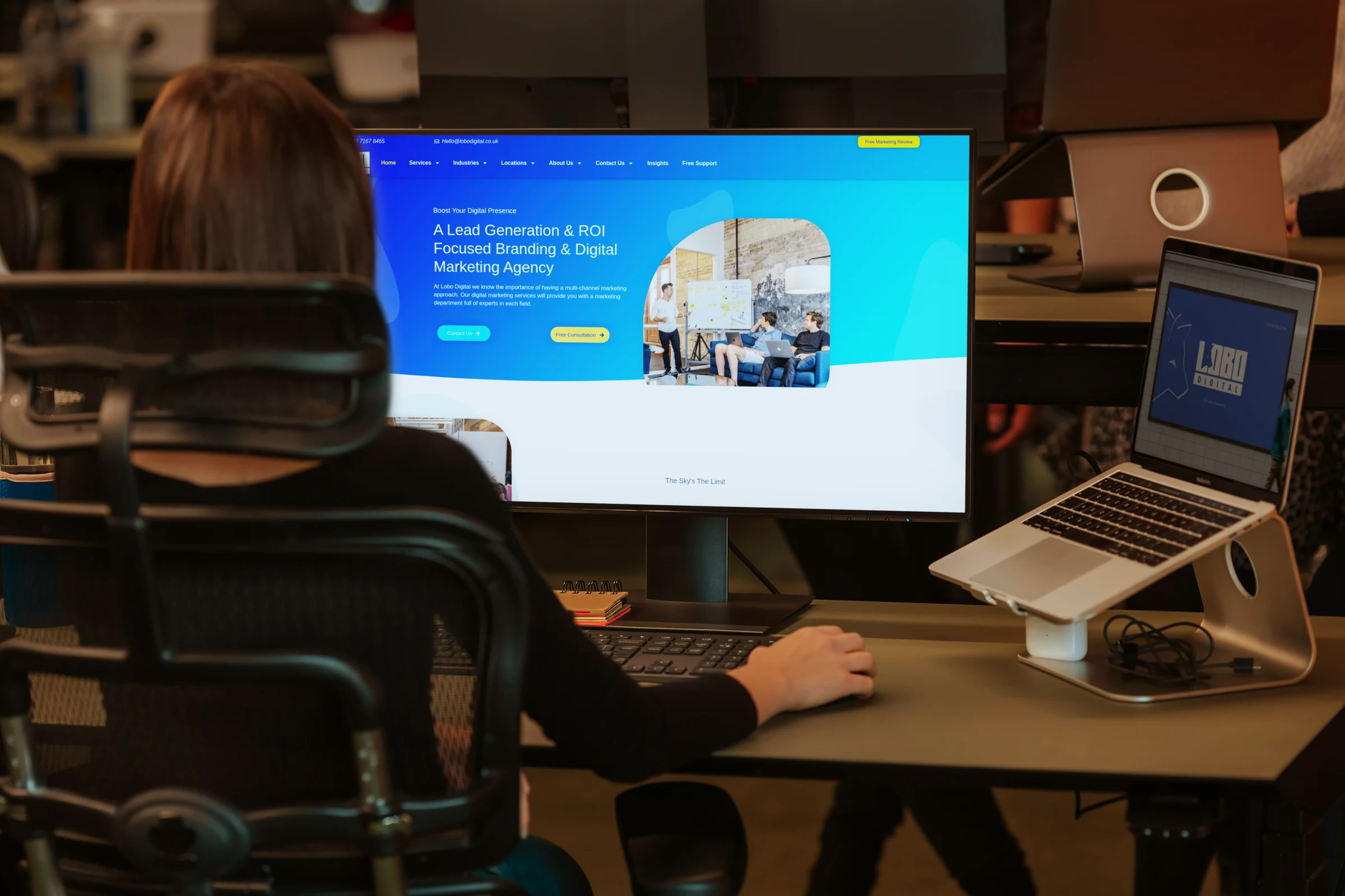 Woman working at computer showing the Lobo Digital website
