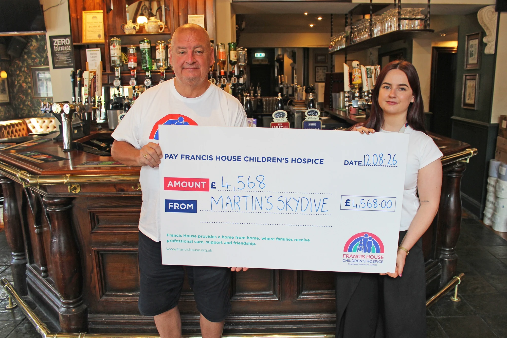 Martin Devlin, general manager of the Fletcher Moss presents Laura Birch of Francis House with a cheque for £4,568