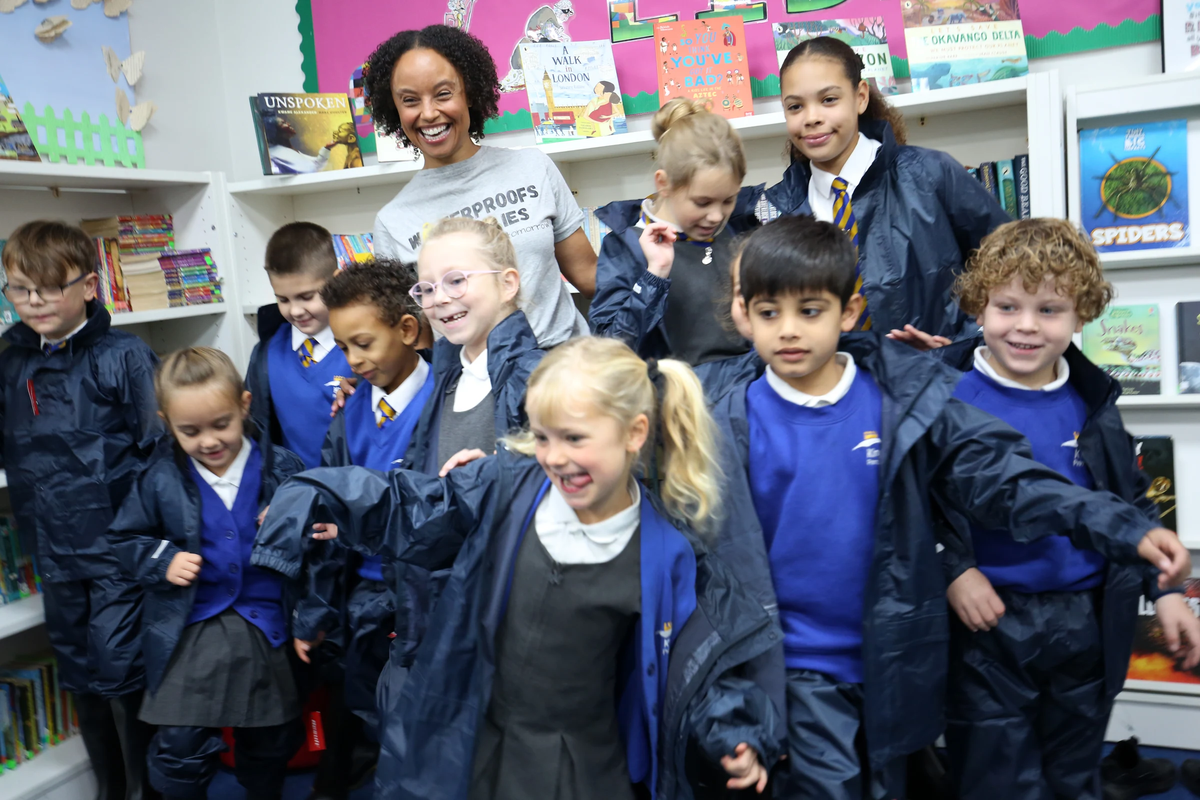 Gemma Hunt and children celebrate the delivery of outdoor clothing kits supporting inclusive outdoor learning .