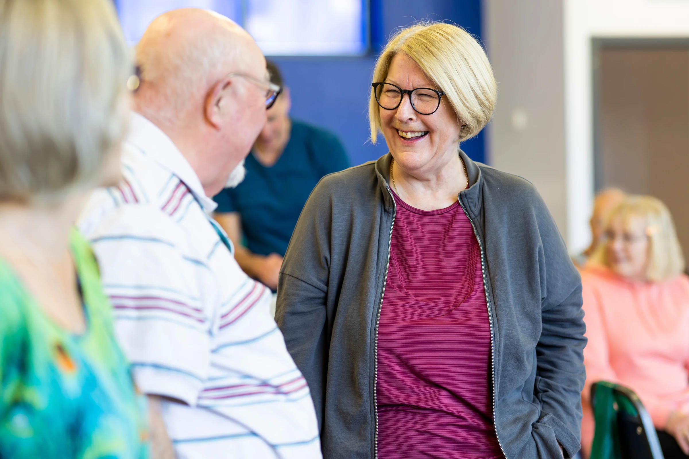 Older woman smiling while chatting to man