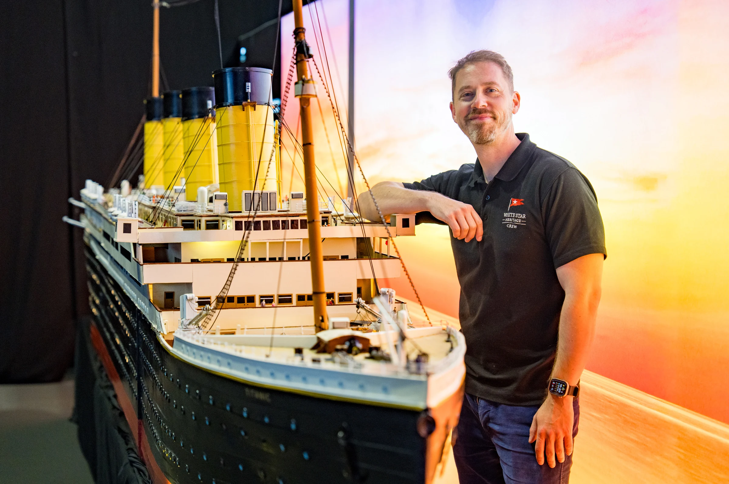 Director Tom Rudderham next to a model of the Titanic