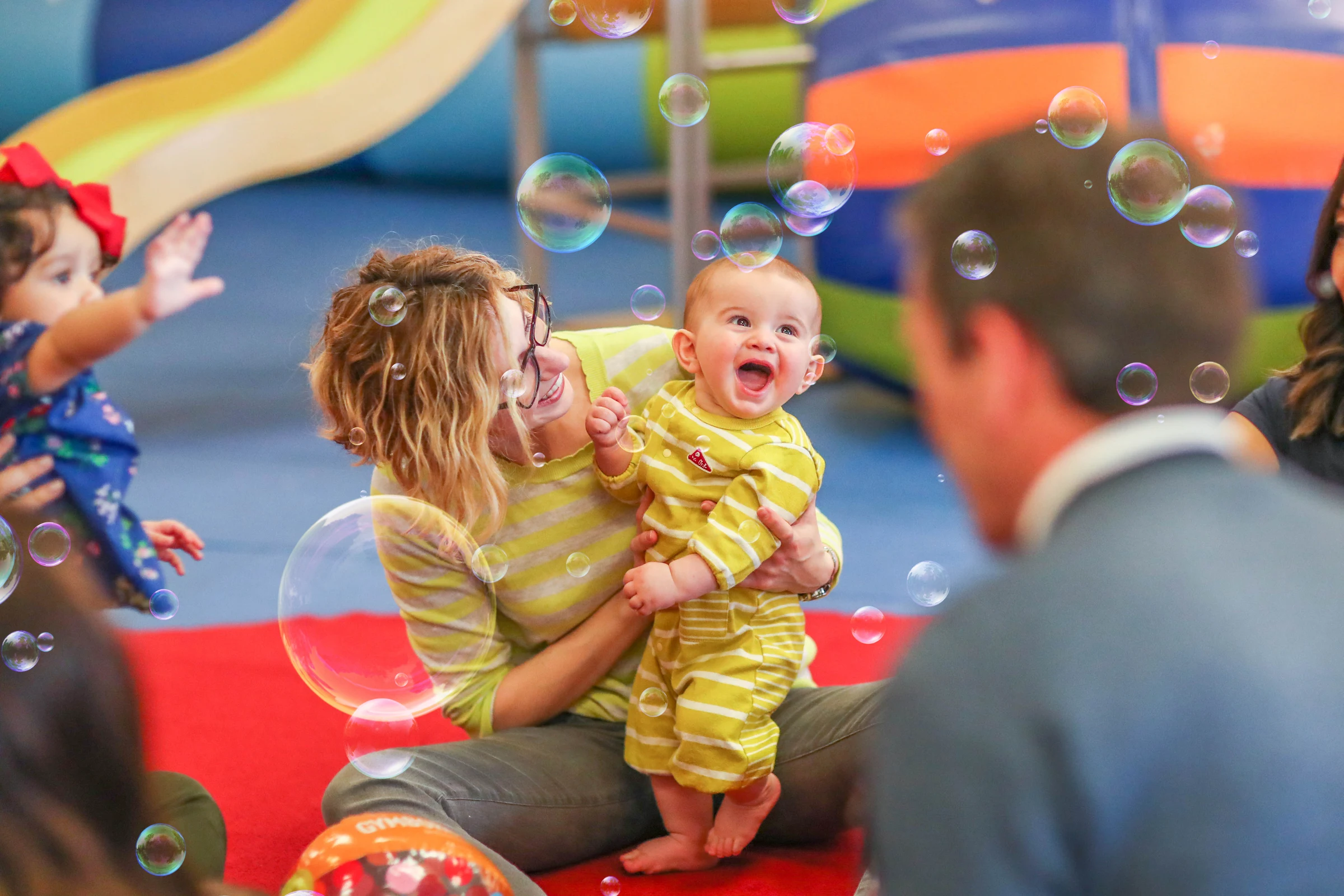 happy baby watching the bubbles in a Gymboree Play & Music class
